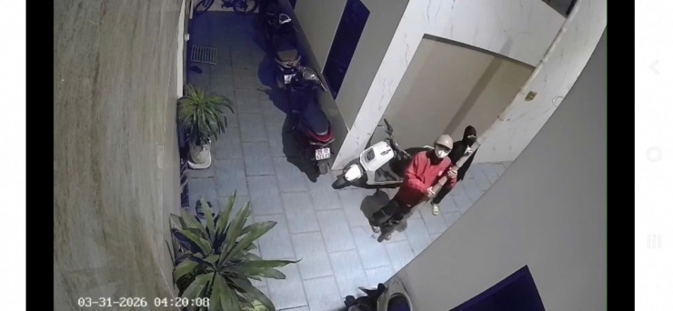 Sau đó, thanh niên áo đỏ đứng dưới, giữ cây tre để thanh niên áo đen trèo lên, đột nhập vào nhà anh P. (Ảnh: Trích xuất camera)