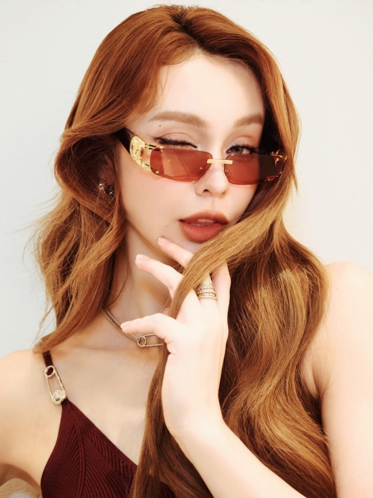 Ca sĩ kết hợp kính râm độc đáo và túi xách, trang sức cùng hãng, tạo nên tổng thể sành điệu, trẻ trung.