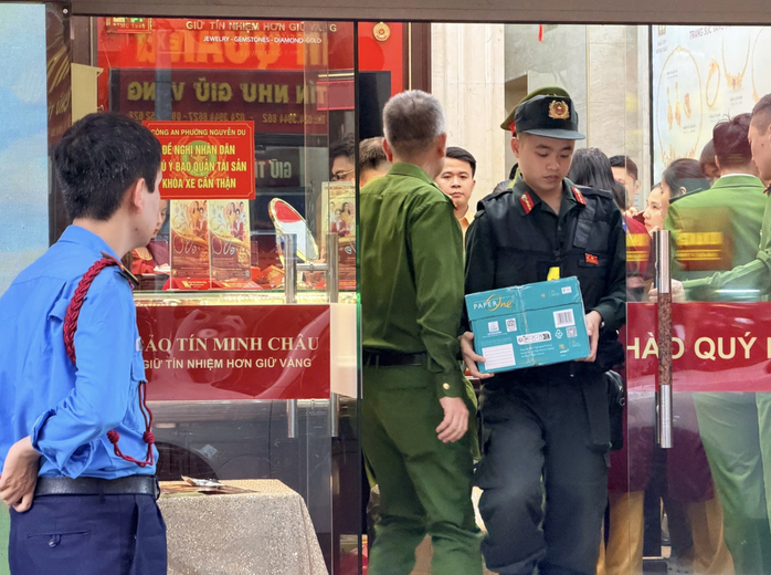 Cảnh sát thu giữ tài liệu tại một cửa hàng Bảo Tín Minh Châu. Ảnh: K.T.
