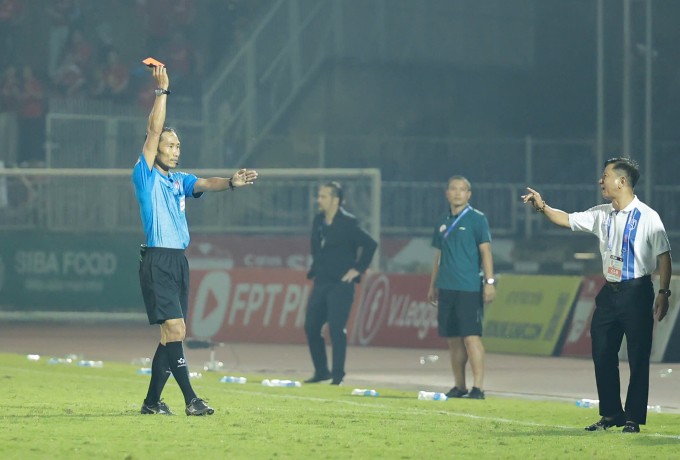 Trọng tài Lê Vũ Linh (trái) rút thẻ đỏ trực tiếp cho HLV thể lực SLNA Phạm Bùi Minh trong trận hòa Thể Công 1-1, ở vòng 17 V-League 2025-2026 trên sân Vinh tại Nghệ An ngày 5/4/2026. Ảnh: Phi Hùng