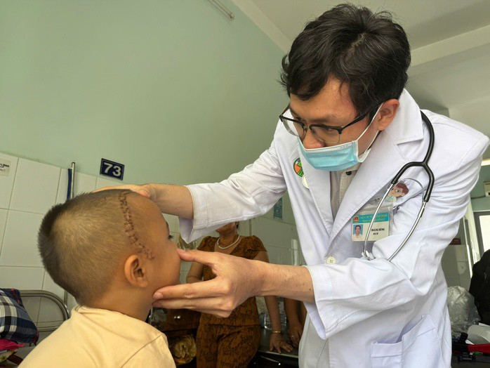 Bác sĩ thăm khám cho bé sau phẫu thuật