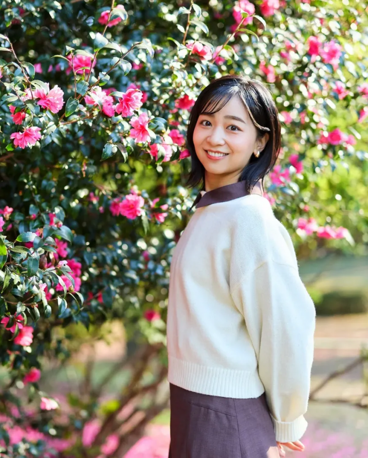 Dịp sinh nhật cuối tháng 12 năm ngoái, cô phối áo len trắng và váy sơ mi tím đậm chụp ảnh bên hoa tại Vườn Hoàng gia Akasaka.