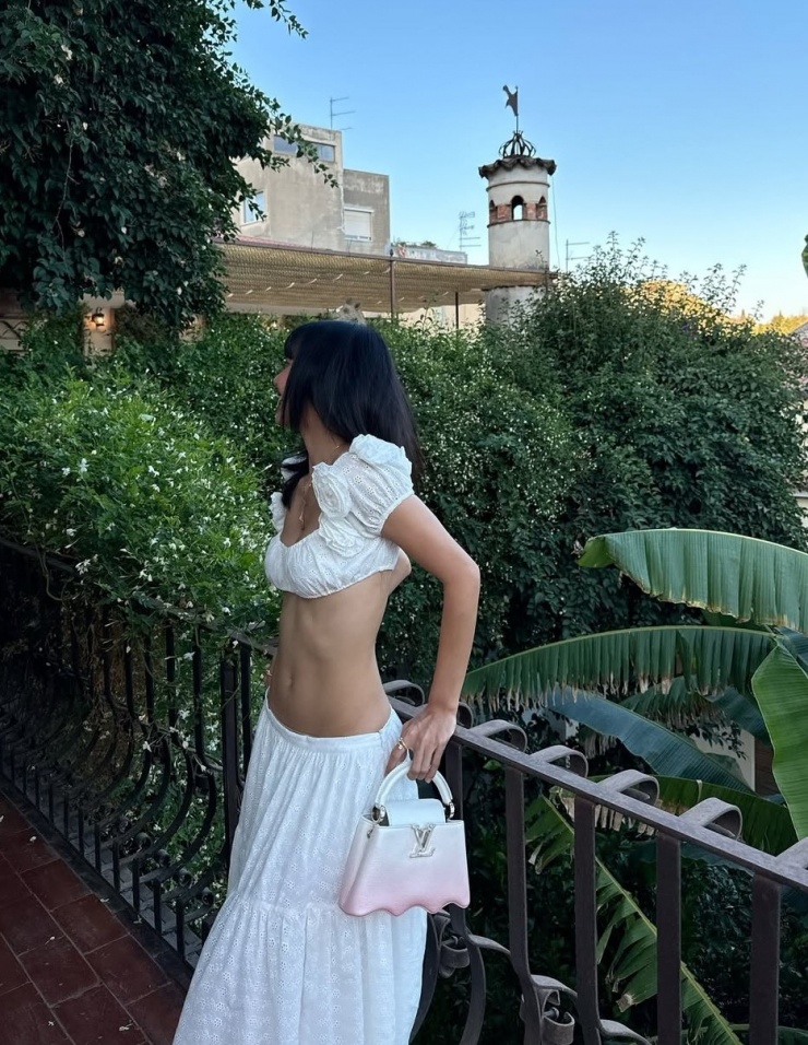 Lisa theo đuổi mốt áo nửa gang tay và chân váy maxi. Túi Louis Vuitton giúp cô tăng vẻ sang trọng.