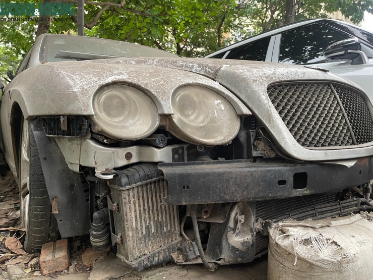 Chiếc xe sang mang biển kiểm soát Hà Nội trong tình trạng xuống cấp nghiêm trọng. Phần đầu xe gần như bị tháo rời, cản trước biến mất, để lộ hệ thống khung, két nước và các chi tiết cơ khí bên trong. Cụm đèn pha mờ đục, nhiều bộ phận đã hư hỏng hoặc không còn nguyên vẹn.