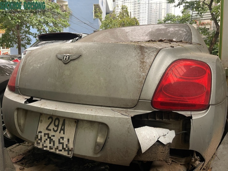 Phần đuôi xe cũng xuống cấp nghiêm trọng khi cản sau hư hỏng, một bên đèn hậu vẫn còn sáng màu nhưng tổng thể đã xuống cấp rõ rệt. Biển số xe bị cong vênh, bám bẩn, cho thấy phương tiện gần như không được di chuyển trong thời gian dài.