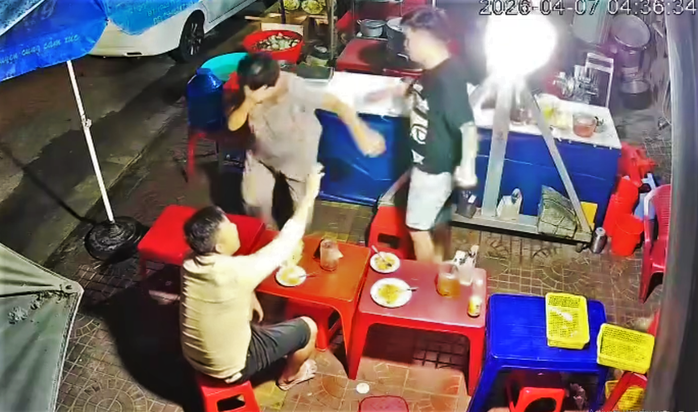 Cụ bà phục vụ trong quán ăn khuya ôm mặt khóc sau khi bị nam thanh niên dùng tay đánh vào mặt. Ảnh cắt từ clip