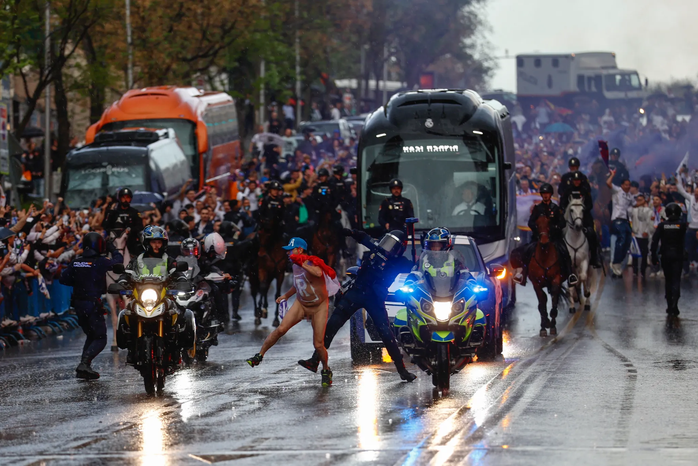Một người đàn ông khỏa thân chạy ngang qua trước xe buýt chở đội Real Madrid. Ảnh: EPA