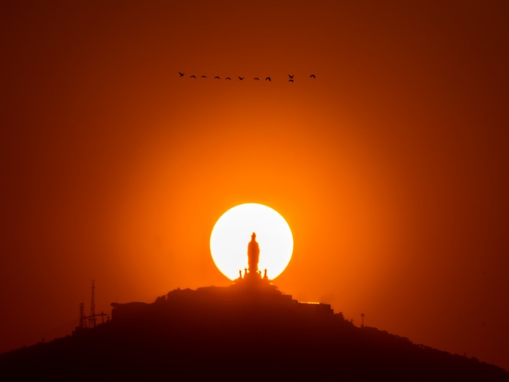 Mặt trời lặn “ôm trọn” tượng Phật Bà Tây Bổ Đà Sơn trên đỉnh núi Bà Đen. Ảnh: HẢI TRIỀU