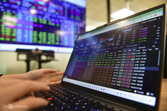 Nhà đầu tư theo dõi bảng giá chứng khoán tại một công ty ở TP HCM. Ảnh: Thanh Tùng