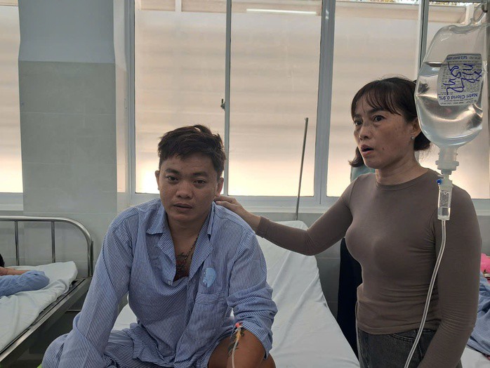 Mẹ ngư dân Nguyễn Văn Vũ chăm sóc cho con tại bệnh viện. Ảnh: Hợp Phố