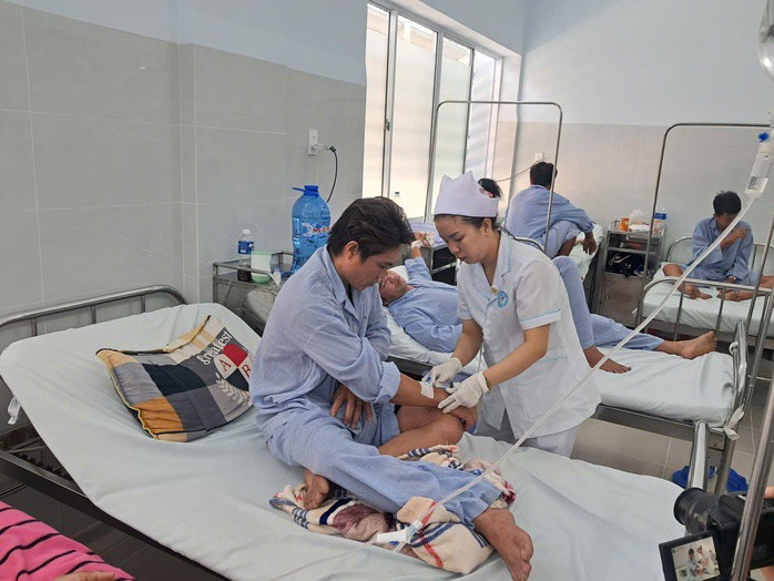 Nhân viên y tế chăm sóc cho anh Nguyễn Văn Sơn. Ảnh: Hợp Phố