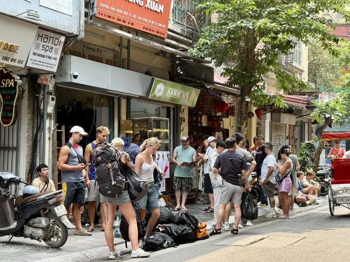 Du khách nước ngoài đứng xếp hàng, chờ đến lượt vào mua bánh mì. Ảnh: Thảo Nhi