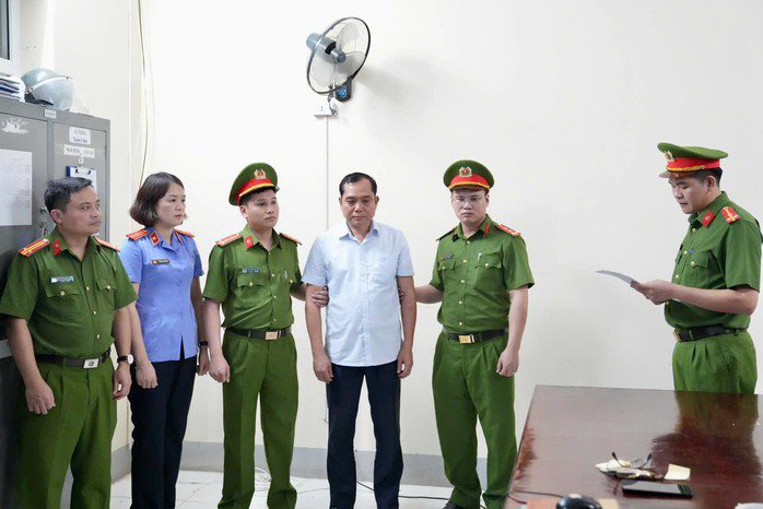 Cơ quan chức năng đọc lệnh bắt giữ Hoàng Trọng Lợi. Ảnh: CACC