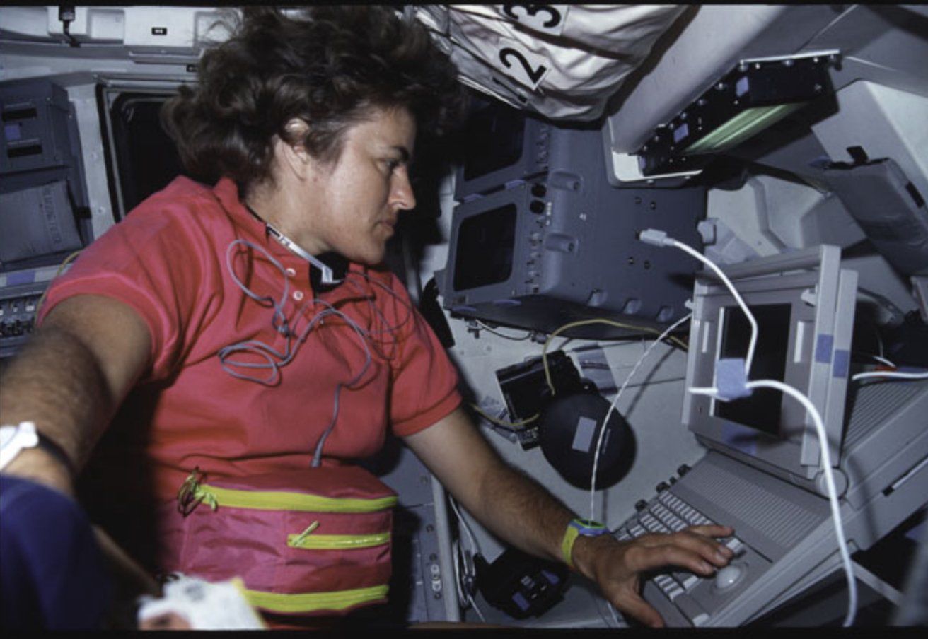 Phi hành gia Shannon Lucid đang làm việc trên một chiếc máy tính xách tay Macintosh trên tàu con thoi Atlantis.