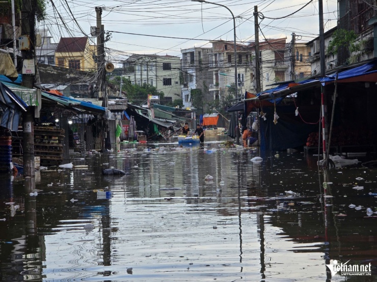 Tiểu thương chợ Vinh lội nước, vớt tài sản sau bão số 10. Ảnh: T.L