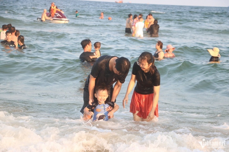 Buổi chiều, Bãi Sau nước trong xanh, có sóng nhẹ nên nhiều gia đình tranh thủ cho con xuống tắm