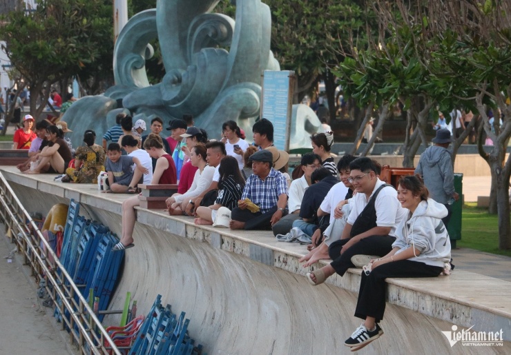 Nhiều người ngồi hóng mát trên bờ kè