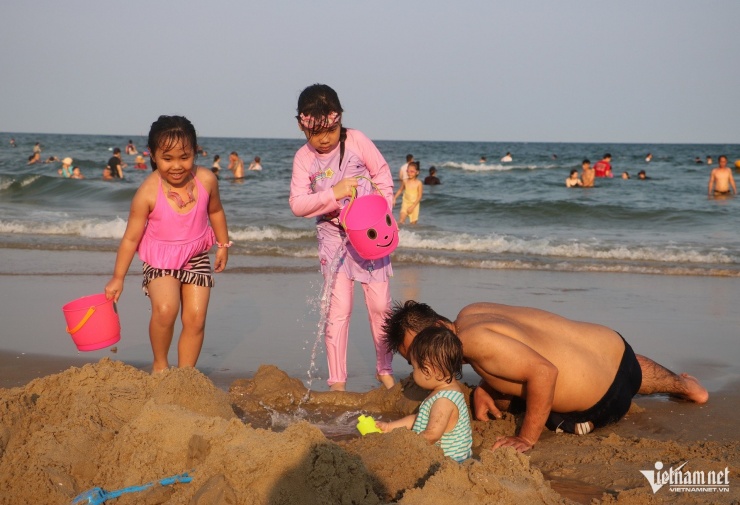 Các em bé nghịch nước, vui chơi trên bờ cùng bố