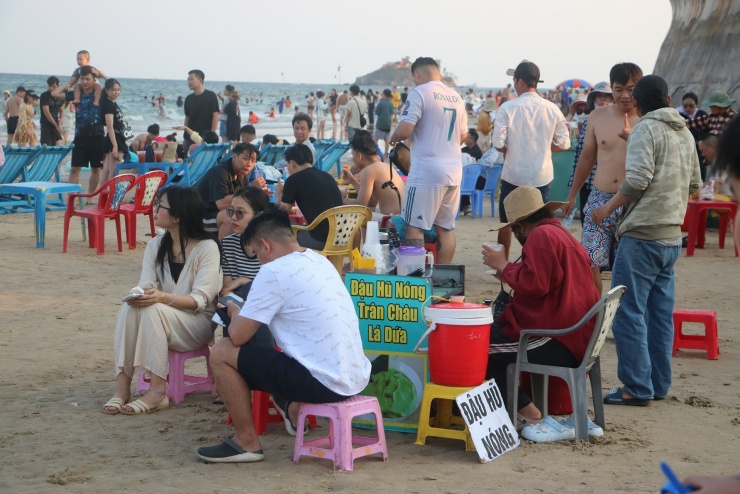 Du khách ngồi ngắm biển, thưởng thức món đậu hũ nóng trên bờ biển