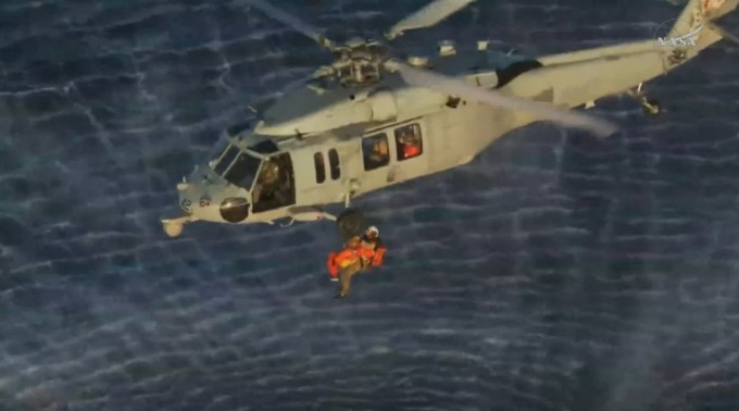 Phi hành gia Reid Wiseman, chỉ huy nhiệm vụ Artemis II, được đưa lên trực thăng quân sự của Mỹ để được vận chuyển đến tàu USS John P. Murtha. Ảnh: NASA