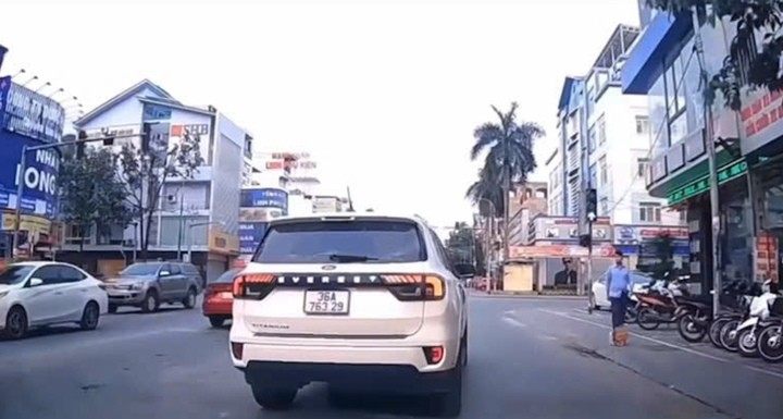 Chiếc ô tô Ford màu trắng loại 7 chỗ gắn biển số 36A-763.29 ngang nhiên lấn làn, chèn ép xe khác giữa phố ở Thanh Hoá. (Ảnh cắt từ clip)
