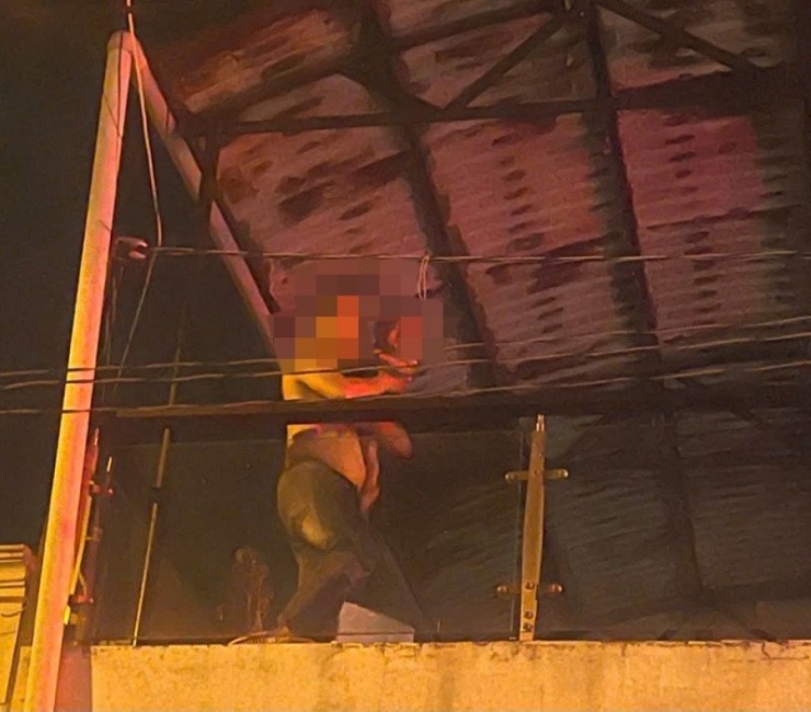 Cán bộ an ninh cơ sở leo lên sân thượng cứu cháu bé. Ảnh: P.L