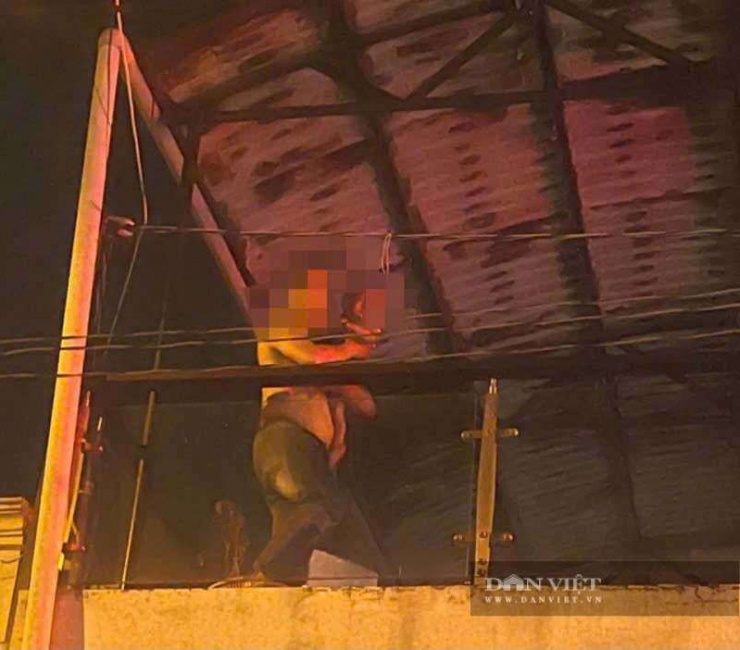 Chiến sĩ Công an phường Tân Thới Hiệp leo sân thượng cứu cháu bé 1 tuổi thành công trong vụ cháy ngôi nhà trọ 4 tầng ở đường Nguyễn Thị Thơi. Ảnh: MX