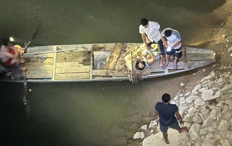 Hai mẹ con cùng anh Khánh được thuyền đánh cá đậu gần đó đưa vào bờ an toàn. Ảnh: Nam Đàn