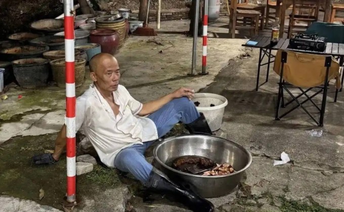 Hình ảnh ông Mo ngồi bệt dưới nền đất, dáng vẻ mệt mỏi được tái hiện bằng AI.