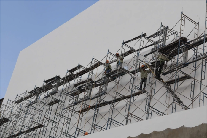 Các công nhân sơn lại phần bên ngoài khối nhà