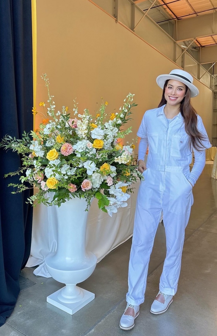 Phạm Hương tạo dáng trước cửa hàng hoa.