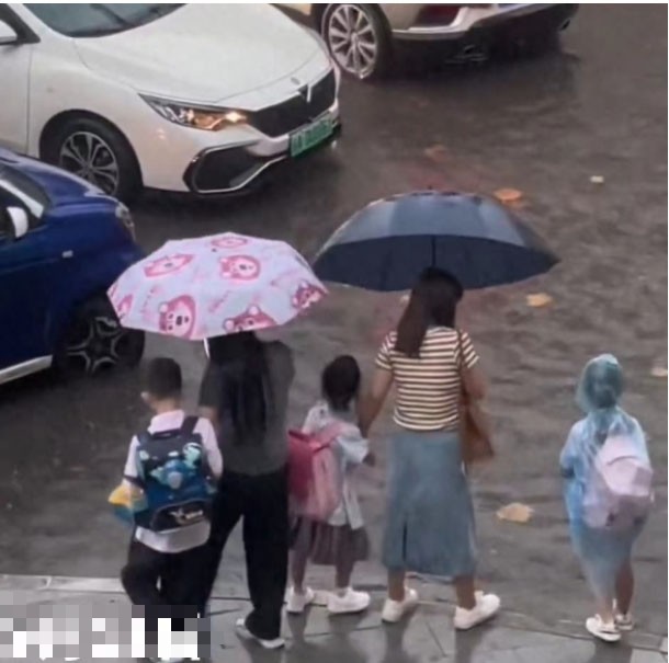 3 đứa trẻ đứng trước quãng đường ngập nước sâu. Ảnh cắt từ clip