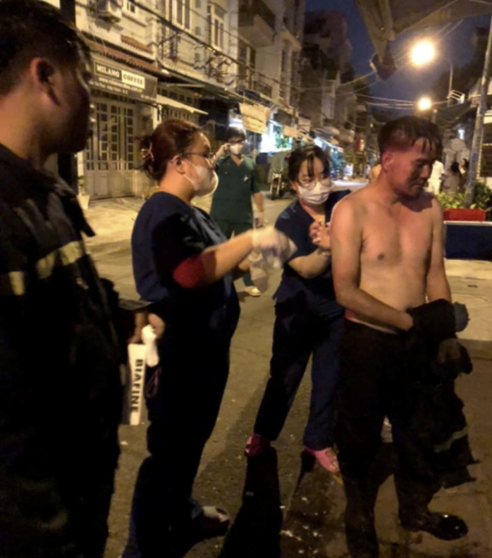 Một cán bộ PCCC cứu nạn cứu hộ được sơ cứu vết thương sau vụ cháy