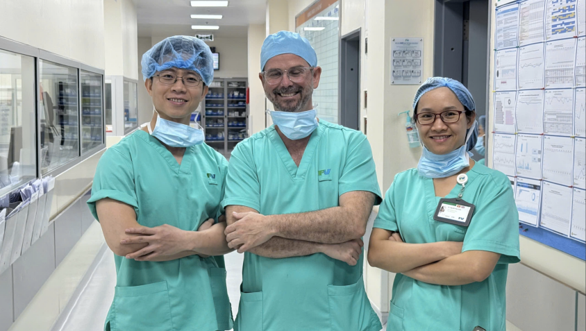 BS. Christophe Perruchoud&nbsp;cùng BSCKI. Nguyễn Nam Bình (phải)&nbsp;và BSCKI.&nbsp;Phạm Hoàng Mạnh (trái) bên ngoài phòng mổ FV