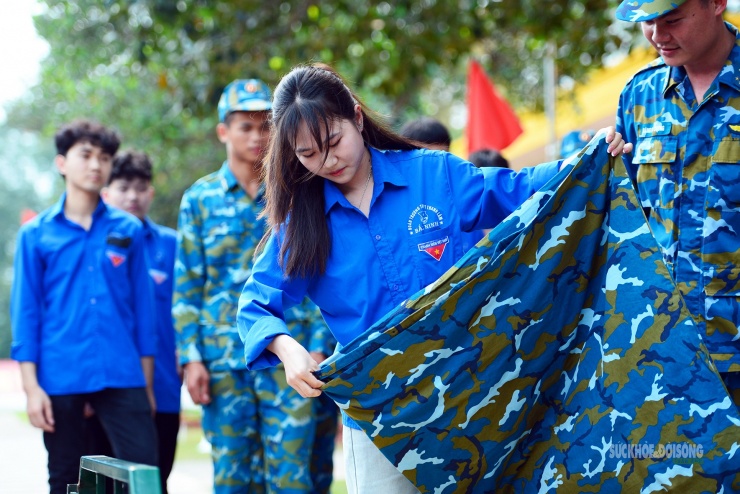 Em Trần Thị Liên cẩn thận thực hiện từng nếp gấp dưới sự hướng dẫn của chiến sĩ.