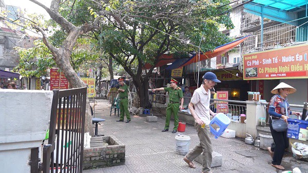 Công an phường Kim Liên xử lý các hành vi vi phạm như: lấn chiếm lòng đường, vỉa hè để kinh doanh buôn bán... Ảnh: Anh Tú.