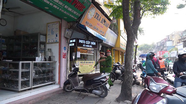 Công an phường Kim Liên nhắc nhở các hộ kinh doanh chấp hành nghiêm các quy định của pháp luật. Ảnh: Anh Tú.