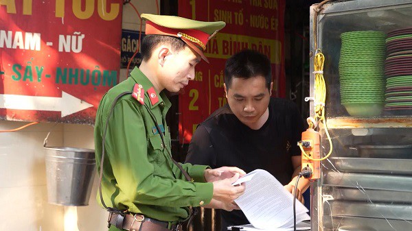 Ông Lê Xuân Thủy ký cam kết chấp hành quy định pháp luật về đảm bảo trật tự đô thị. Ảnh: Anh Tú.