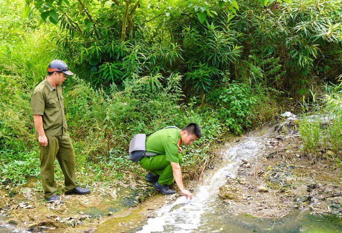 Lực lượng c&ocirc;ng an lấy mẫu nước khu vực suối D&ograve;ng S&ocirc;ng để l&agrave;m r&otilde; nguy&ecirc;n nh&acirc;n sự cố m&ocirc;i trường