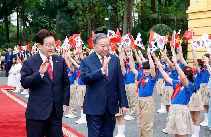 Tổng Bí thư, Chủ tịch nước Tô Lâm và Tổng thống Hàn Quốc Lee Jae Myung với thiếu nhi tại lễ đón. Ảnh: TTXVN