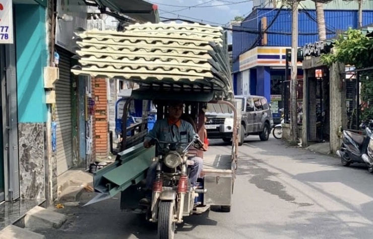 Hình ảnh phương tiện chở hàng hóa cồng kềnh di chuyển trên đường phố.