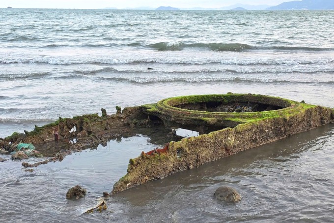 Xác xe tăng trồi lên bãi biển Quy Nhơn khi thủy triều rút. Ảnh: Quốc Cường