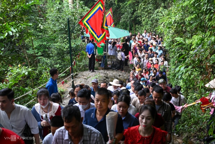 Tại đường lên đền, dòng người nhích từng bước, nhiều thời điểm phải đứng yên tại chỗ. Tại đây, cảnh sát và thanh niên đứng ở bên bờ vực liên tục nhắc nhở người dân không chen lấn.