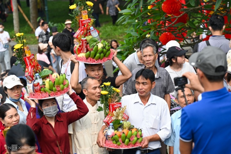 Người dân mang theo đồ lễ vất vả chen trong dòng người đông nghẹt.Bà Bùi Thị Đốc, 69 tuổi, quê Yên Thủy (Hòa Bình cũ), cho biết xuất phát từ 4h cùng đoàn 30 người. Do lượng người quá đông, bà bị lạc đoàn và không đủ sức khỏe nên phải quay lại chân núi Nghĩa Lĩnh để nghỉ ngơi.