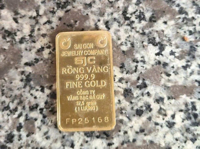 Tấm kim loại có các ký hiệu vàng SJC 1 lượng mà cụ ông mang theo.