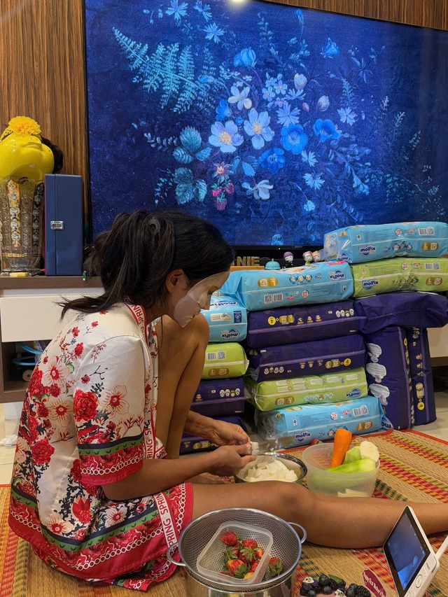 Nàng hậu vừa chăm sóc da vừa chuẩn bị đồ ăn cho ái nữ. Tuy nhiên, điều khiến nhiều "mẹ bỉm" chú ý còn là chồng bỉm cao ngất ngay bên cạnh.