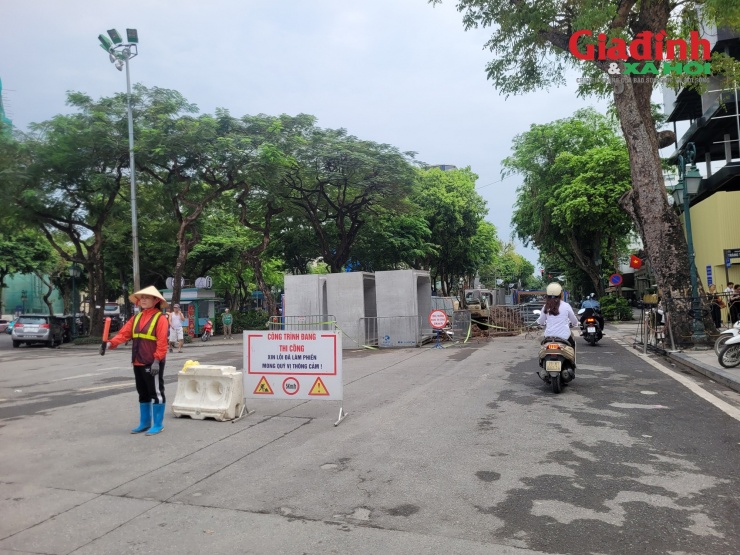 Tại đoạn thi công giữa lòng đường Phan Chu Trinh (đoạn gần giao Nhà hát lớn), phần giữa lòng đường được quây kín bằng rào chắn cố định theo từng đoạn dài hàng chục mét, công nhân liên tục hỗ trợ điều phối phương tiện tại đầu công trường.