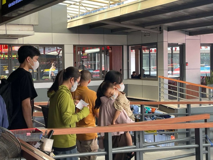 Các em nhỏ được bố mẹ bế trên tay ra xe để về quê nghỉ lễ 30/4 - 1/5.