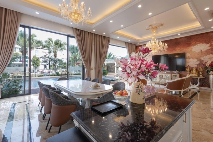 Phòng khách thông với không gian bếp có tầm nhìn ra bể bơi với cửa kính cỡ lớn, giúp ngôi nhà luôn tràn ngập ánh nắng tự nhiên.