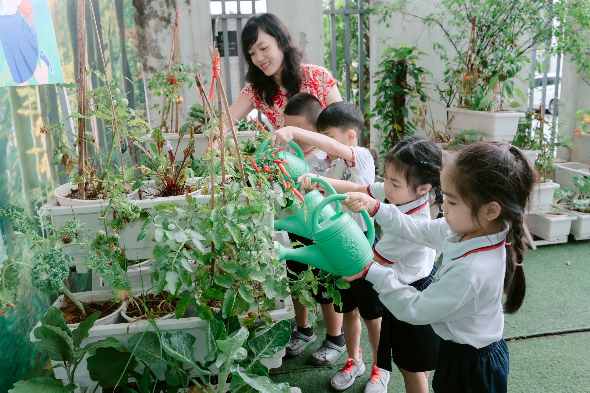 Giáo viên hướng dẫn các em học sinh cách chăm sóc cây hàng ngày tại vườn ươm của trường Tiểu học Tây Sơn (P. Hai Bà Trưng).